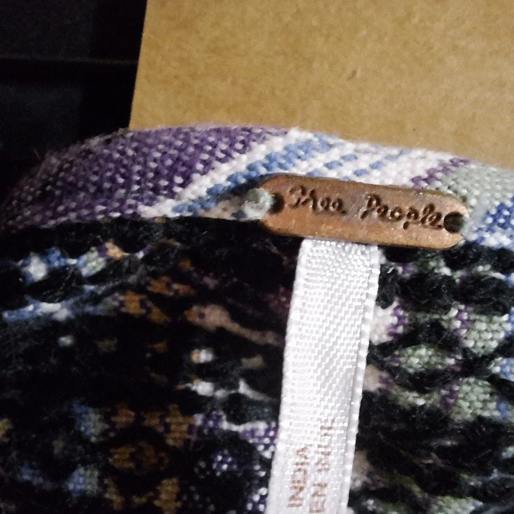A Free People long sleeve blouse with string ties in the front in a size small.